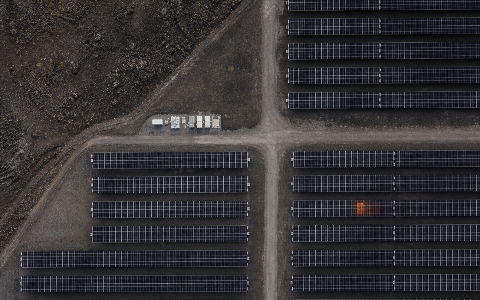 Vista aérea cenital de una instalación fotovoltaica sobre terreno volcánico